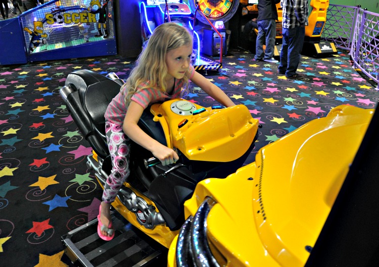 Kaylee playing a motorcycle game at John's Incredible Pizza in Buena Park, CA