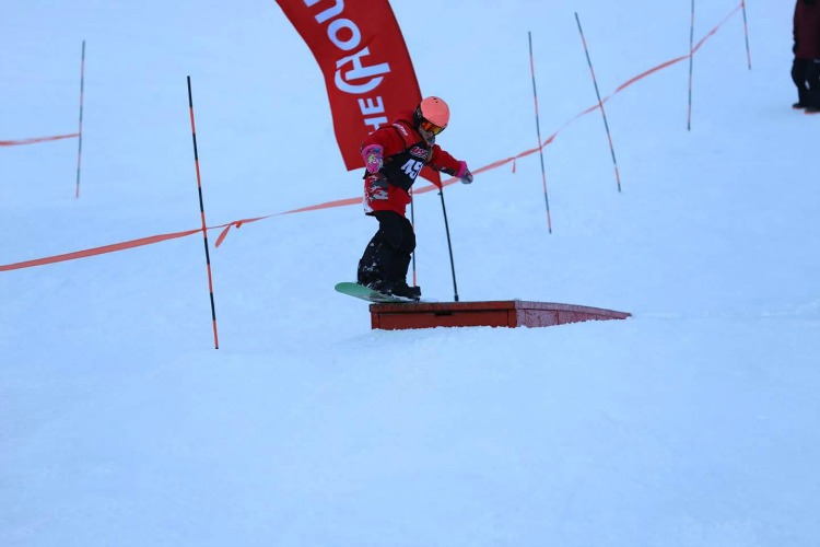 Zoë riding a box at Rail Jam