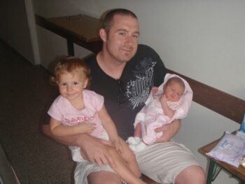 Brian holding Zoë and Kaylee for the first time