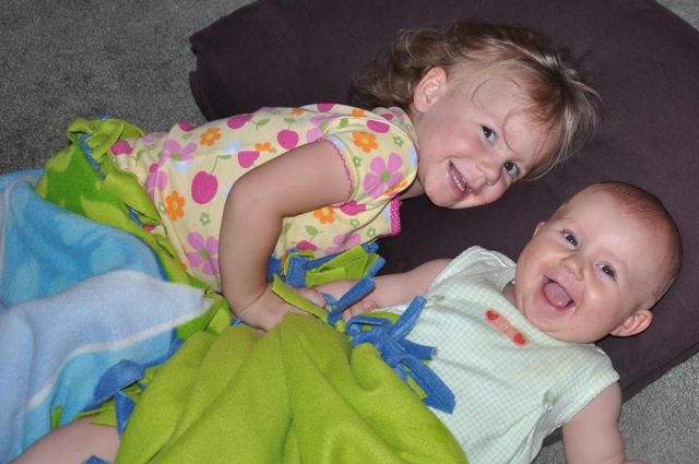 Zoë and Kaylee snuggling on the floor with a big pillow and blankie