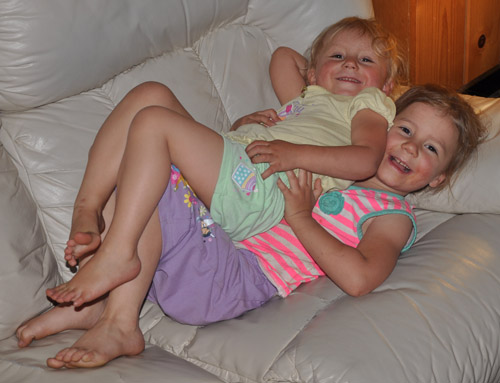 Zoë and Kaylee snuggling on the couch