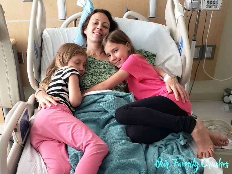 Chrystal in a hospital bed with Zoe and Kaylee