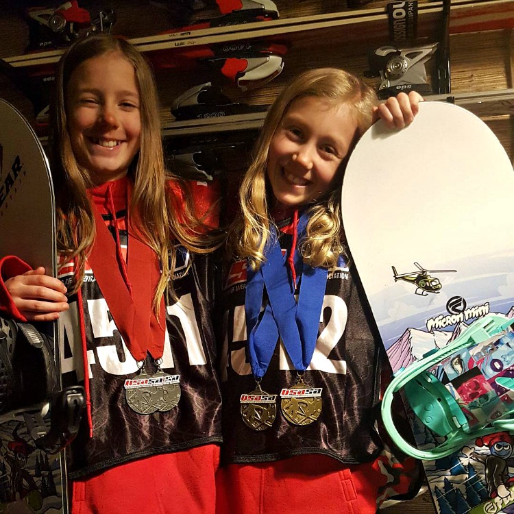 Zoe and Kaylee with their snowboards and medals