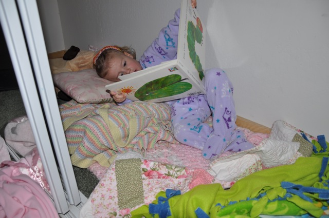 Zoë reading a book in the closet