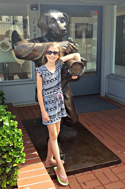 Zoë standing with a dog statue in La Jolla, CA