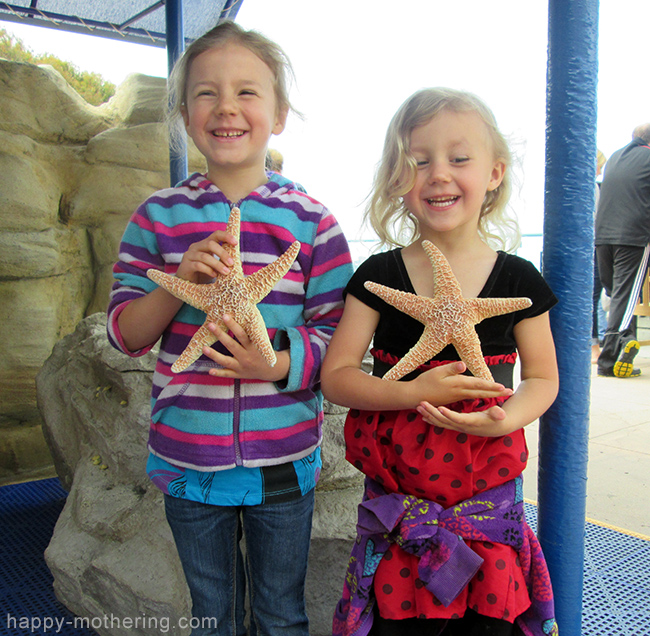 Zoë and Kaylee holding star fish at Birch Aquarium La Jolla