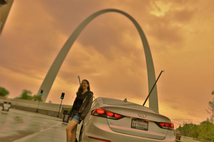 Chrystal standing by the Elantra Eco in front of the St. Louis arch