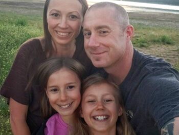 The Johnson family smiling for a picture at the lake
