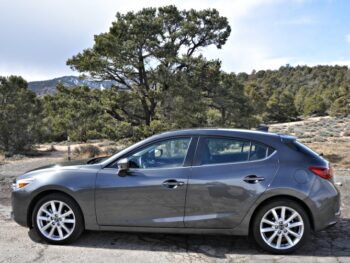 Side view of gray Mazda3 with nature in the background