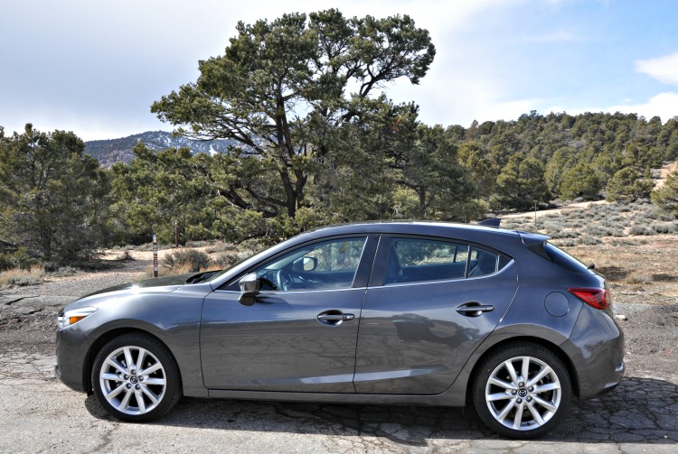 Side view of gray Mazda3 with nature in the background