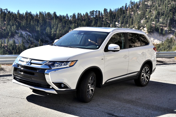 Front angle of white Mitsubishi Outlander on mountain roads