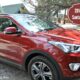 Red Hyundai Santa Fe in a rocky driveway