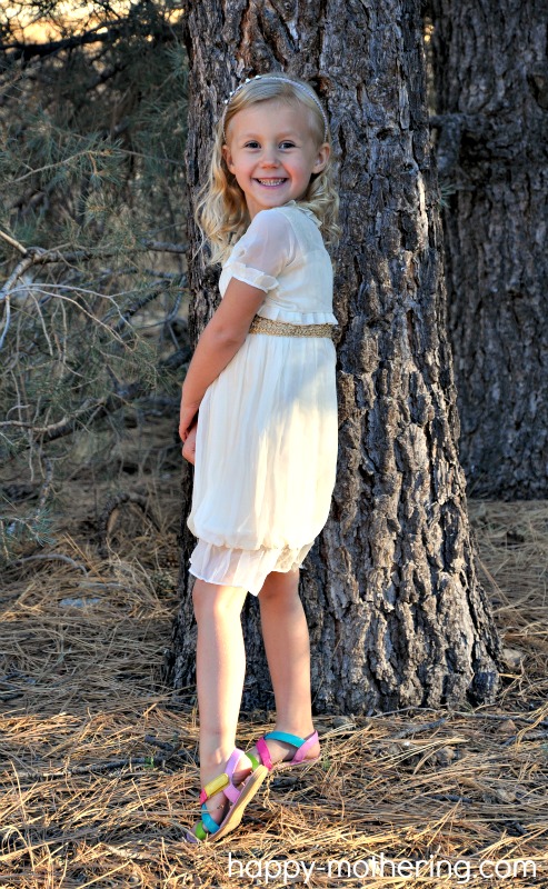 Kaylee posing in front of a pine tree in her Janelle Funari handmade dress