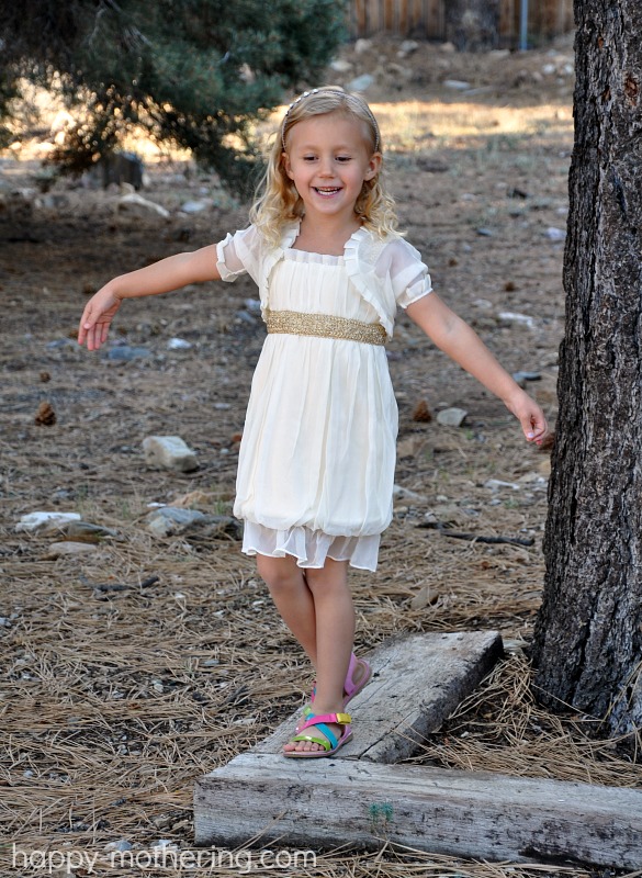 Kaylee balancing on a beam while modeling her Janelle Funari dress