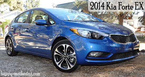 Blue Kia Fore in rock covered driveway