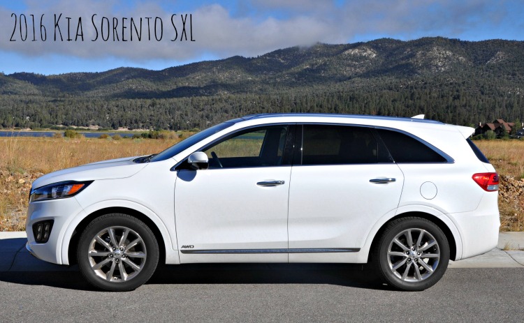 White Kia Sorento with the mountains and lake in the background