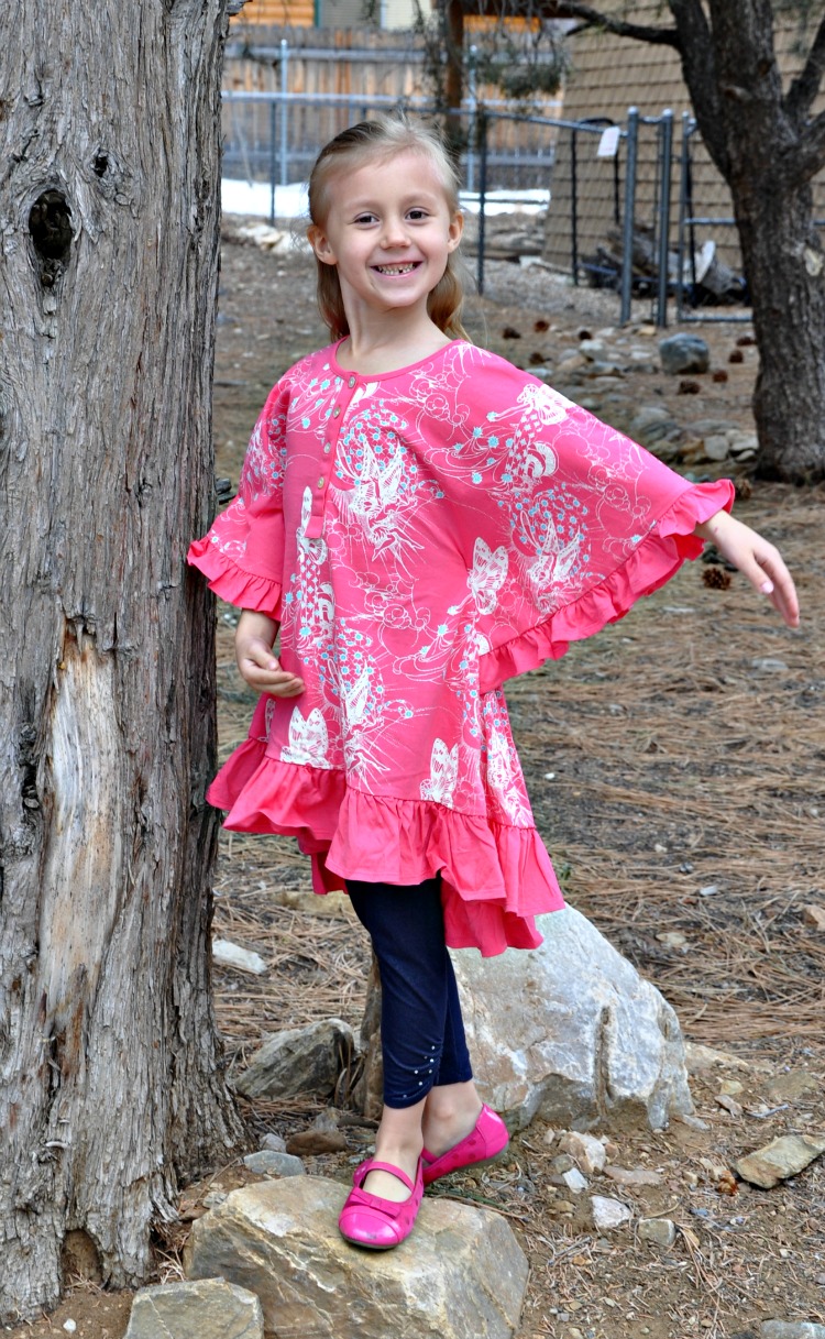 Kaylee doing a ballet pose under a tree in her Little Skye Boutique top