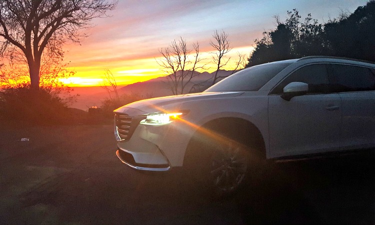 Mazda CX-9 at sunset with mountains and trees in the background