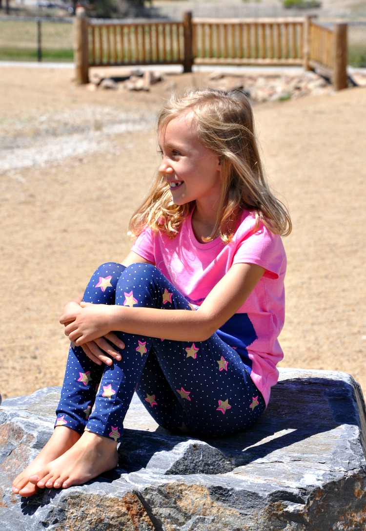 Kaylee sitting on a boulder at the park