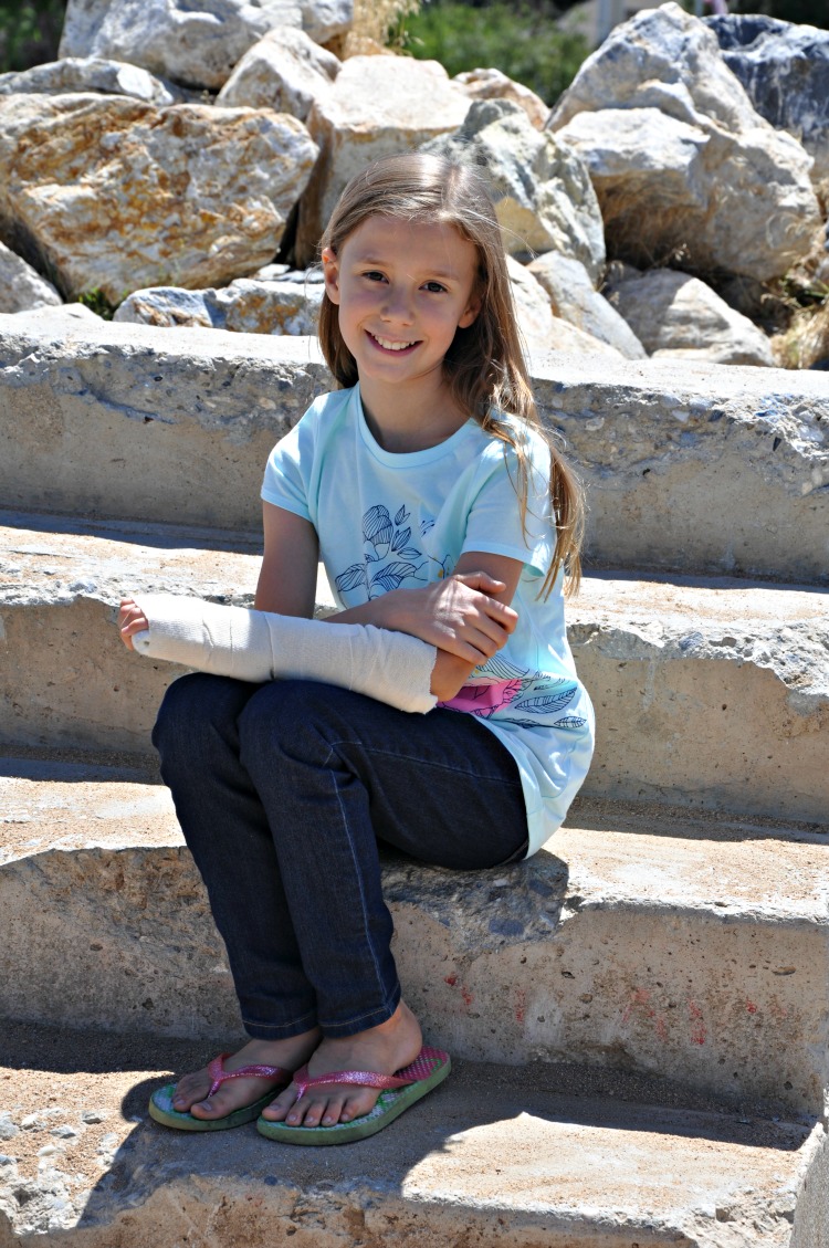 Zoë sitting on old cement stairs by the lake