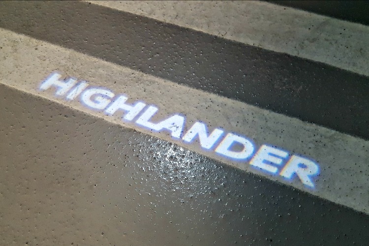 "Highlander" written in lights on the ground from the vehicle