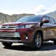 Front angle of Toyota Highlander Hybrid with green mountains in the background