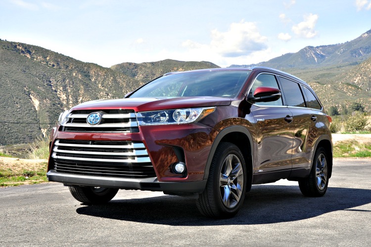 Front angle of Toyota Highlander Hybrid with green mountains in the background
