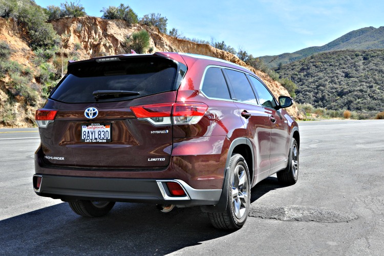 Back of a red Toyota Highlander Hybrid heading up mountain roads