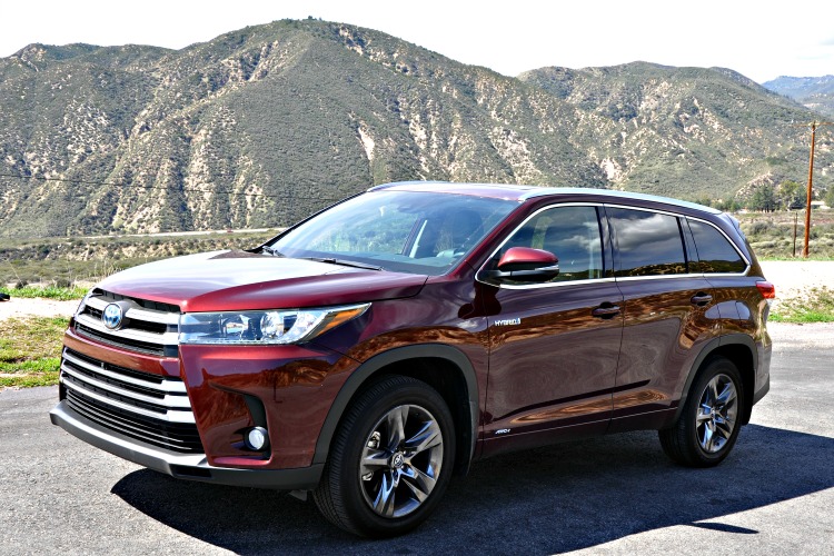 Side of red Toyota Highlander Hybrid in front of mountains