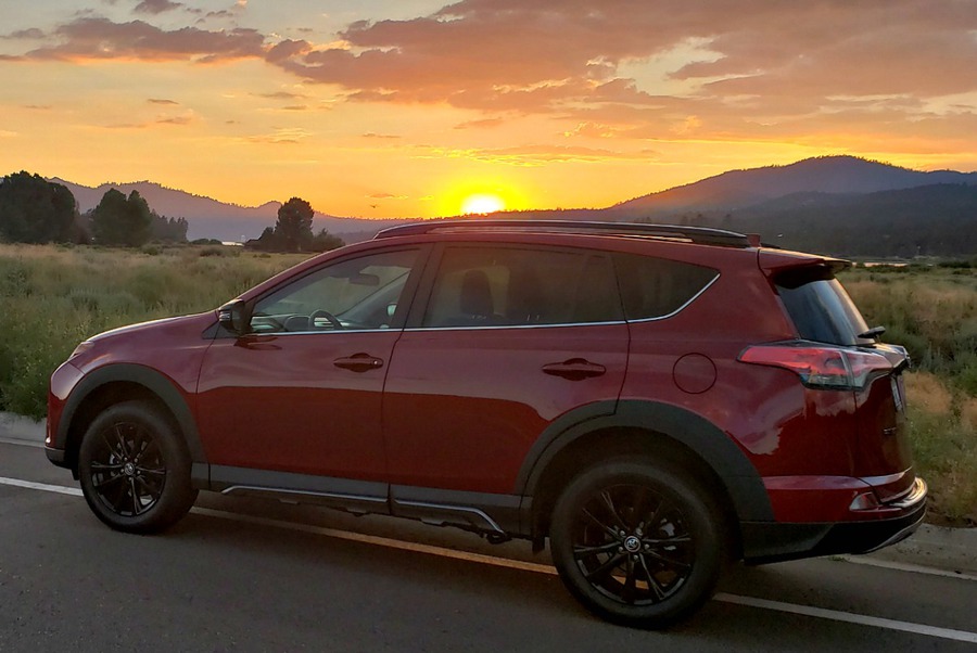 Red Toyota RAV4 at sunset with mountain in the background