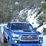 Blue Toyota Tacoma TRD 4x4 Offroading on snowy mountain roads
